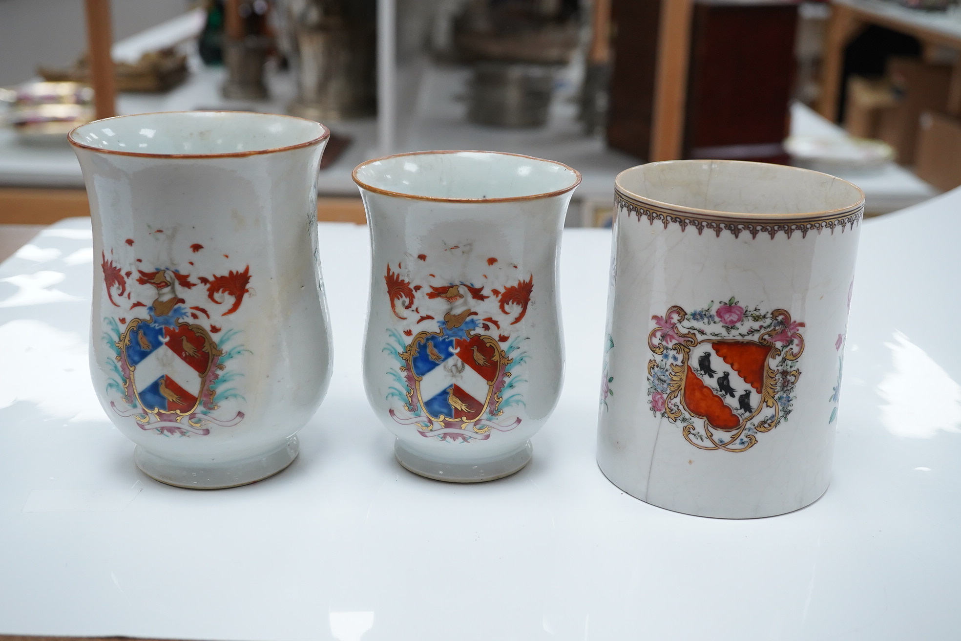 Three 18th century Chinese export armorial mugs, largest 14cm high. Condition - all restored